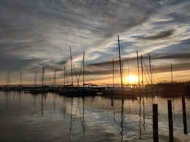 Der Hafen von Szigliget bei Sonnenuntergang mit Booten im Hintergrund